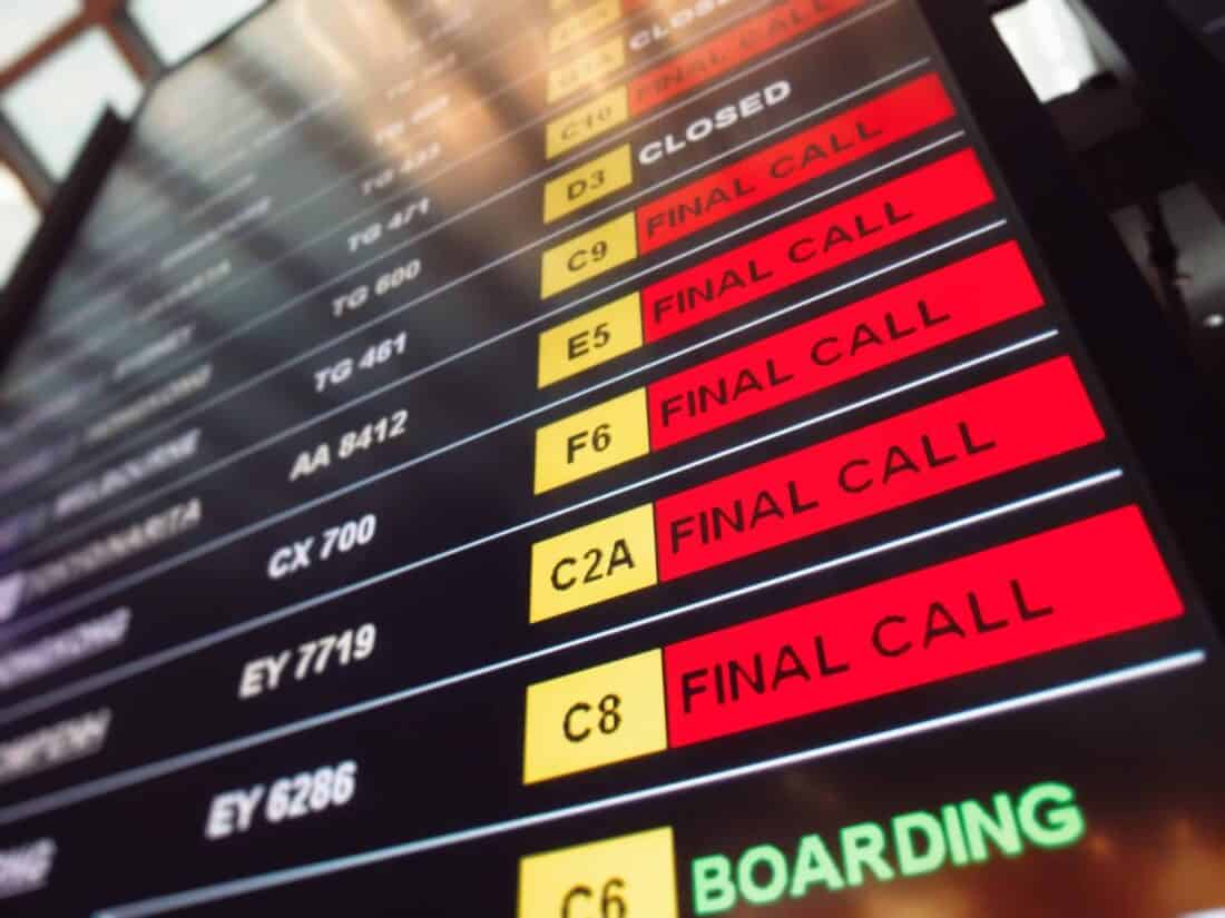 Many red sign final call flights on the departure table of an airport